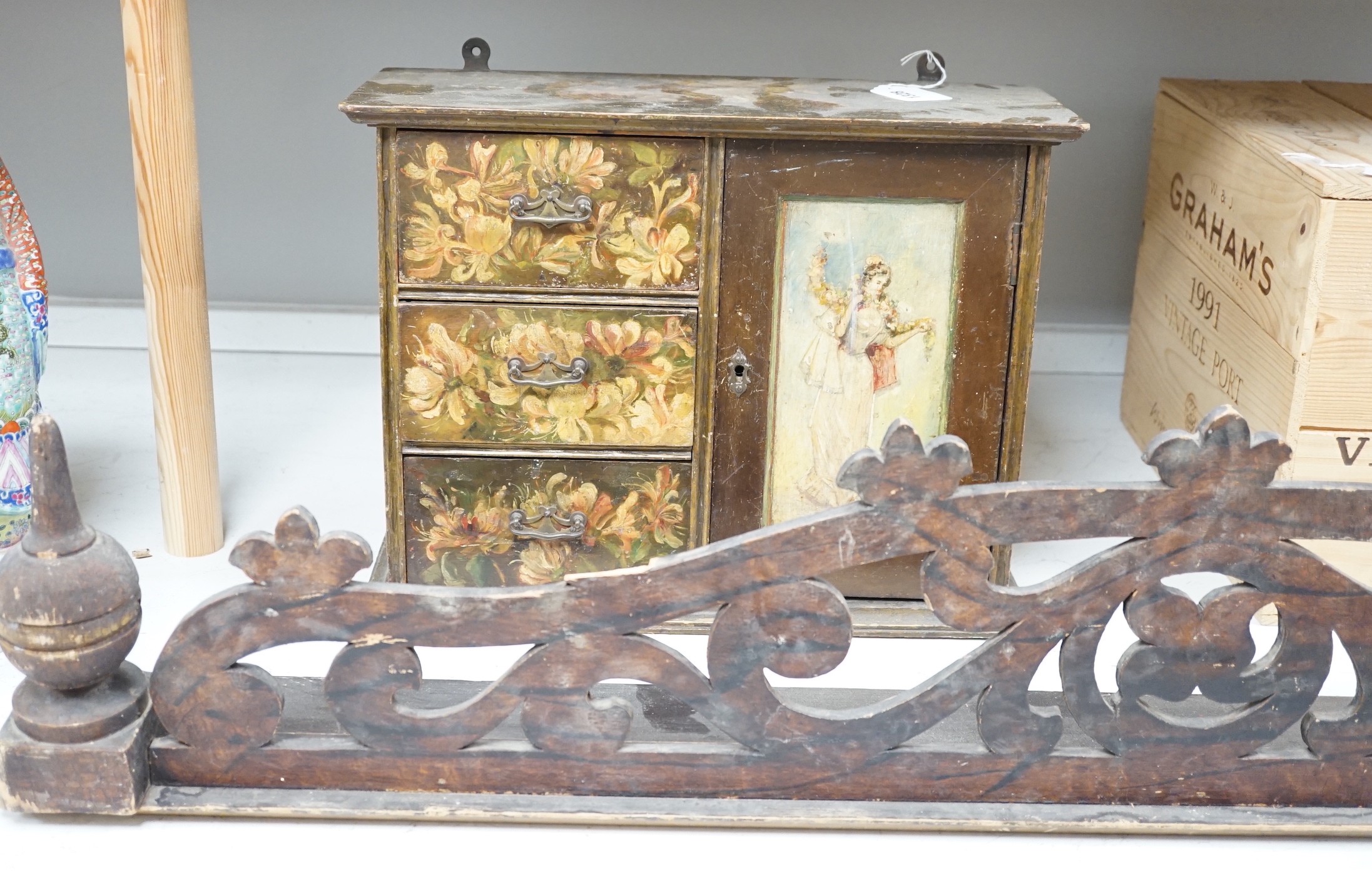 A painted wood hanging wall cupboard and a fret carved and grained wood pediment, 124cm